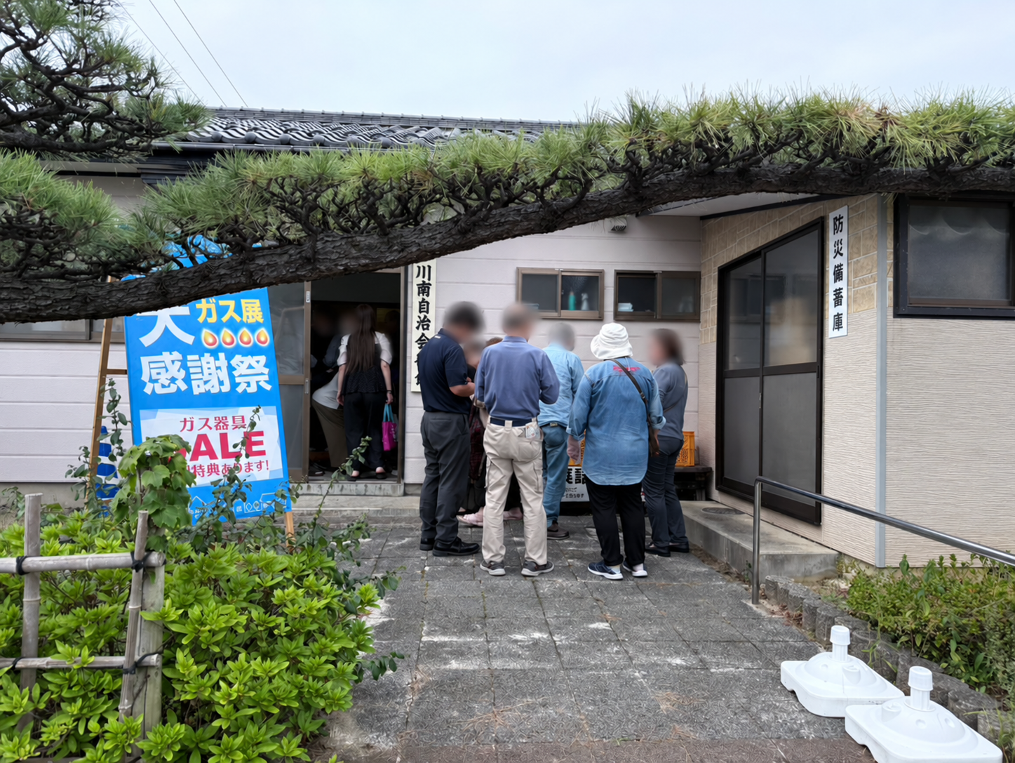 秋のガス展の入り口で来場者が集まり、会話する様子。人物の顔はぼかしています。