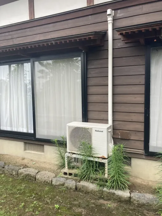 酒田市 交換前の室外機（サビの出た古い架台とブロック置き）