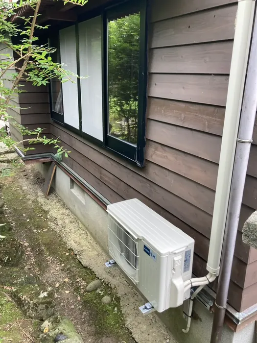 酒田市 交換後の室外機（外壁の壁面架台に設置・配管をまとめて固定）