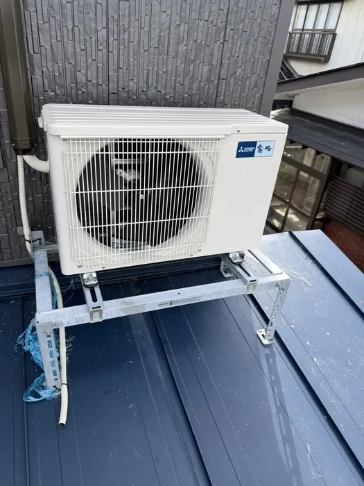 酒田市 交換後の室外機（下屋根の上に屋根置き架台を組んで嵩上げ設置）