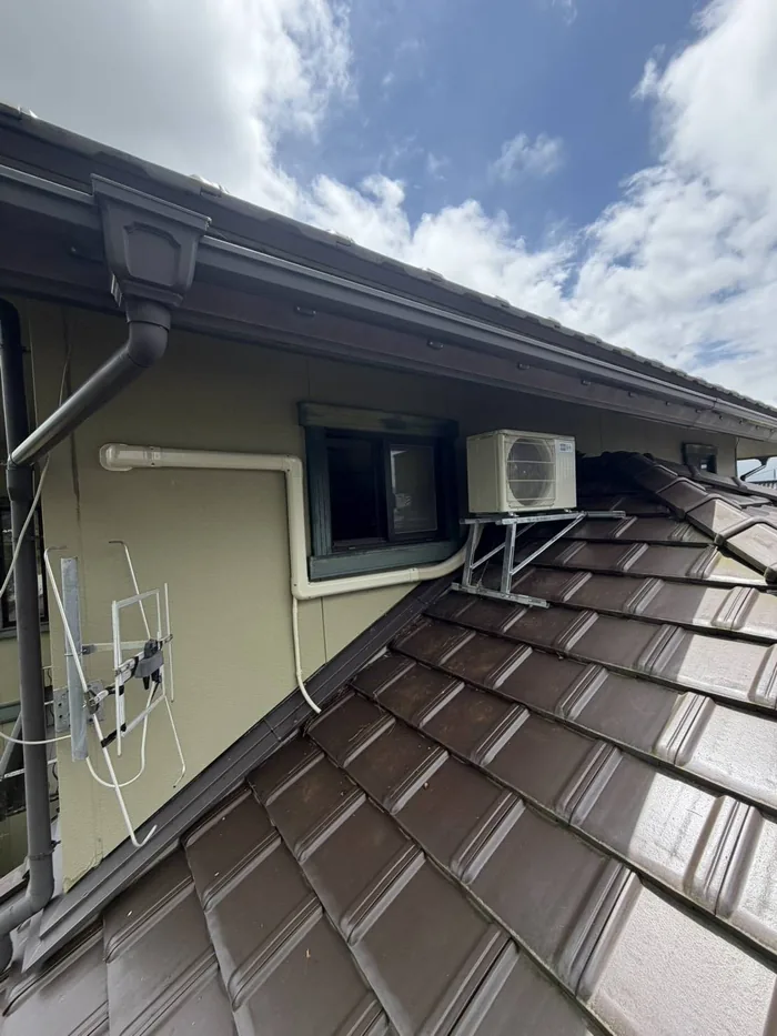 鶴岡市 交換後の室外機（瓦屋根の上に新しい屋根置き架台を組んで設置・配管は化粧カバー仕上げ）