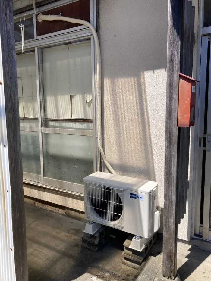 鶴岡市 交換後の室外機（既設のブロックの上に新しい据付台を敷いて水平に設置）