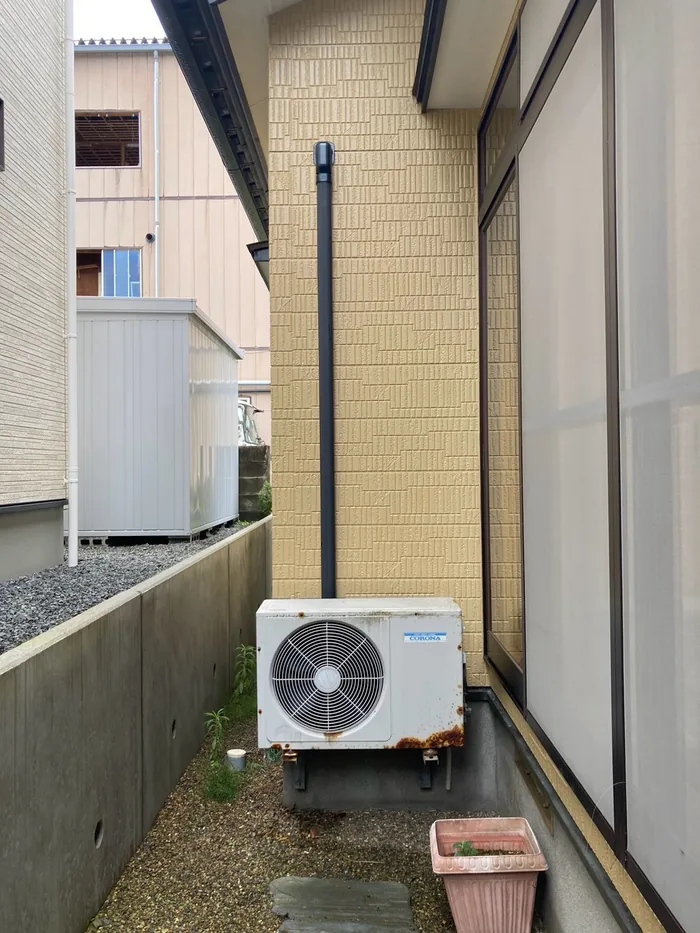 酒田市若竹町 交換前の室外機（サビの出た旧型室外機と色あせた化粧カバー）